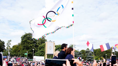 FILE PHOTO. French officials hold the Olympic flag in Paris, France.